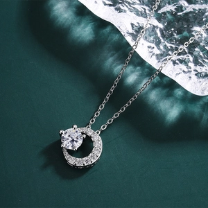 Macro shot of a 2ct moissanite crescent moon pendant necklace on a cold ice background