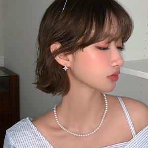 Elegant zircon star earrings and pearl necklace set worn by a woman for a chic look
