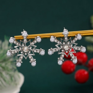 Macro view of snowflake earrings with pearls and crystals on a festive display