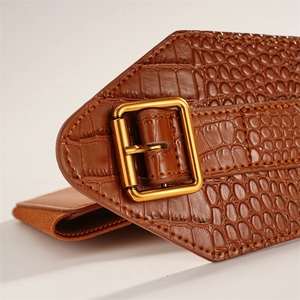 Detail of brown crocodile pattern elastic waist belt with a golden square buckle