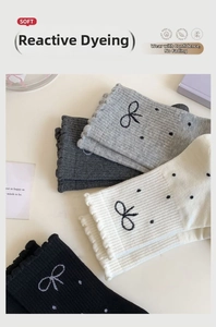 Detailed view of polka dot bow socks with ruffled edges in black, grey, and beige