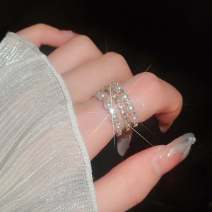 Detail of multi-layer gold ring with pearls and pavé diamonds on model's finger