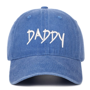 Detail of white DADDY embroidery on washed denim blue cotton baseball cap with stitch texture