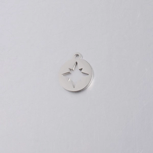 Detail of mirror polished stainless steel compass pendant with hollow star cutout