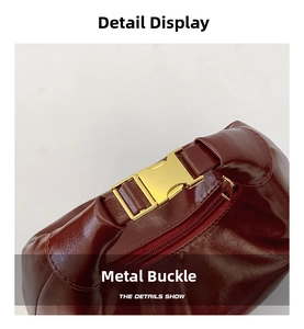 Close-up of wine red glossy leather bag with gold metal buckle and zipper detail