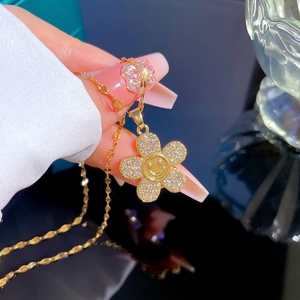 Gold titanium steel necklace featuring a crystal-encrusted flower smiley face pendant