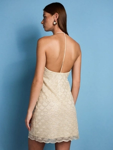 Sequin lace mini dress with backless halter design and scale pattern on blue background