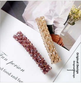 Detail of handmade crystal bead hair clips in deep purple and champagne gold tones