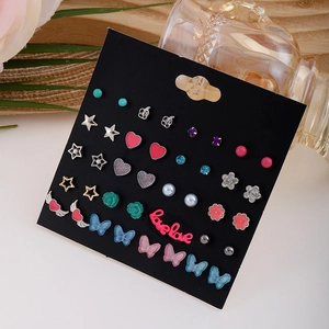 Set di orecchini minimalisti con fiori, farfalle e perle su un cartoncino nero elegante