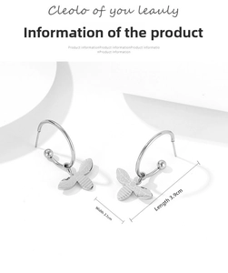 Détail de boucles d'oreilles papillon en argent avec ailes texturées et créoles