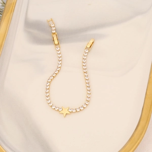 Close-up of 18K gold plated tennis bracelet with sparkling zircons and star charm