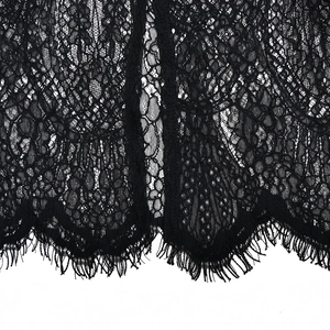 Detail of delicate black lace fabric with eyelash trim and intricate mesh patterns