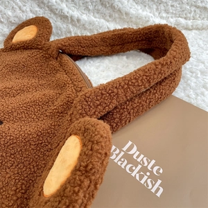 Close-up of large plush teddy bear tote bag showing soft brown faux fur and zipper detail