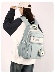 Light blue and beige high-capacity school backpack with cute bear pendant and SUNFLOWER logo
