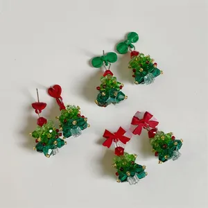 Detail of beaded crystal Christmas tree earrings with red hearts and festive bows