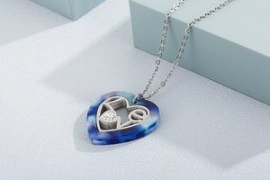 Detail of a silver heart pendant with blue textured inlay and shimmering small crystals