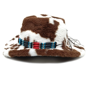 Close-up of cow print cowboy hat with ethnic beaded band and brown plush texture