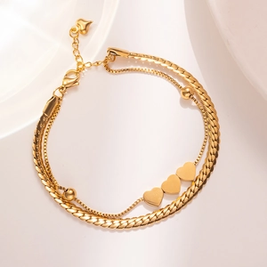Elegant gold double-layered bracelet with heart pendants and flat curb chain texture