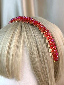 Detail of handmade gold leaf headband featuring red crystal beads on a model