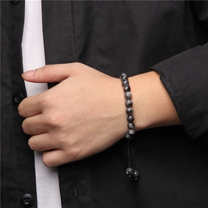 Detailed view of woven tiger eye stone bracelet with adjustable black rope cord