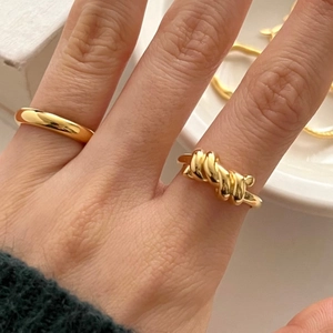 Minimalist 925 silver knotted ring set in gold finish worn on a finger