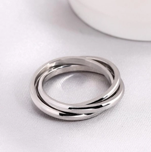 Detailed view of silver interlocking triple bands with polished titanium steel finish
