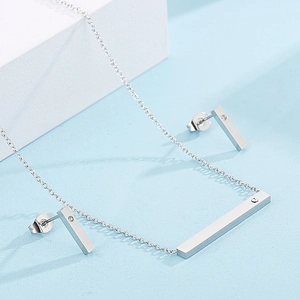 Detailed view of silver bar pendant necklace and matching stud earrings with tiny diamonds