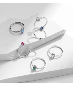 Detail showing 925 sterling silver rings with colorful oval gemstones on a marble display