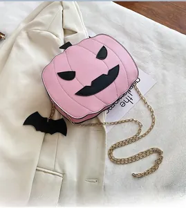 Detail of pink pumpkin-shaped bag with quilted leather, black bat charm and gold chain