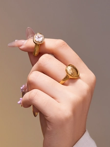 Détail de bagues dorées avec zircon 5A carré et texture martelée sur les doigts