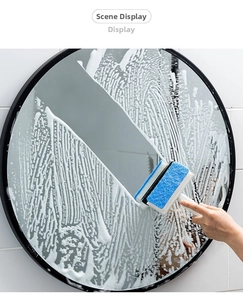 Close-up of a 2-in-1 bathroom glass squeegee removing foam from a round mirror surface