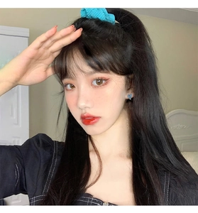 Close-up of blue heart stud earrings and matching sky blue scrunchie on a model