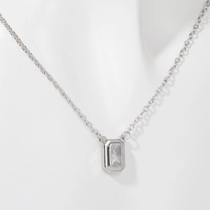 Detail of silver necklace with emerald cut clear zircon pendant on a white mannequin