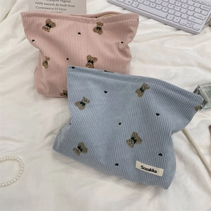 Detailed view of corduroy makeup bags with cute bear pattern in pink and blue