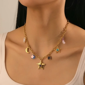 Close-up of gold stainless steel necklace with star, moon and gemstone pendants