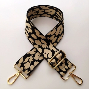 Close-up of leopard print woven strap with adjustable gold buckle and metal hooks