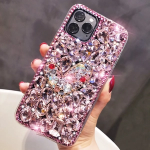 Handheld view of a pink luxury iPhone case with full rhinestones and a jeweled heart