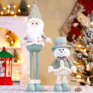 Detailed close-up of Mori green plush Christmas dolls with checkered bowties and warm lighting