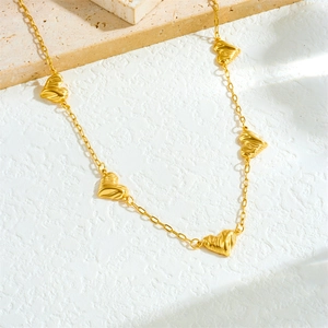 Minimalist gold plated stainless steel necklace featuring textured heart and flower links