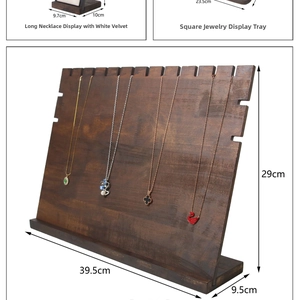 Macro shot of dark walnut wood necklace display board with white velvet lining and jewelry tray