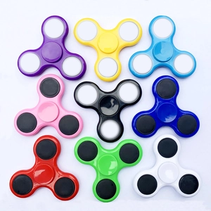Flat lay of colorful three-arm fidget spinners in nine vibrant assorted colors on white background
