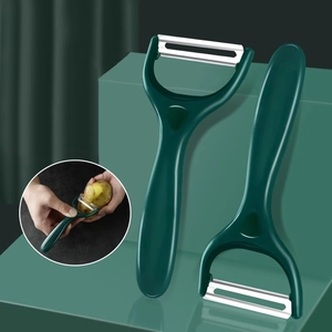 Dual stainless steel vegetable peelers with ergonomic green handles for kitchen use