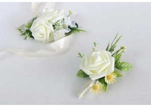 Detail of cream bridal wrist corsage and groom boutonniere with yellow daisy accents