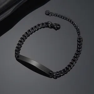 Macro detail of black stainless steel curb chain bracelet with curved blank metal bar plate
