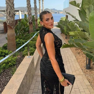 Sexy schwarzes ärmelloses Spitzenkleid mit hohem Schlitz in tropischer Umgebung