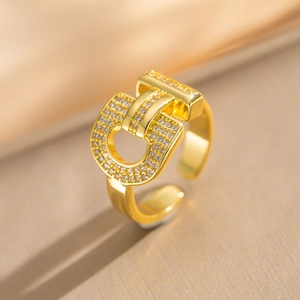 Adjustable golden horseshoe ring with paved crystals on a silk background