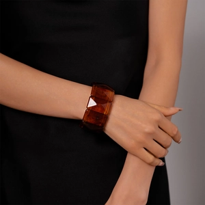 Close-up of deep amber resin geometric bangle showing semi-transparent rectangular beads