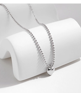 Detail of s925 silver beaded chain bracelet featuring a polished heart pendant on display