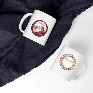 Close-up of two white ceramic Christmas mugs with festive Merry Christmas illustrations