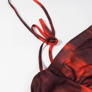 Detail of adjustable thin straps and red black tie-dye fabric texture on floral dress